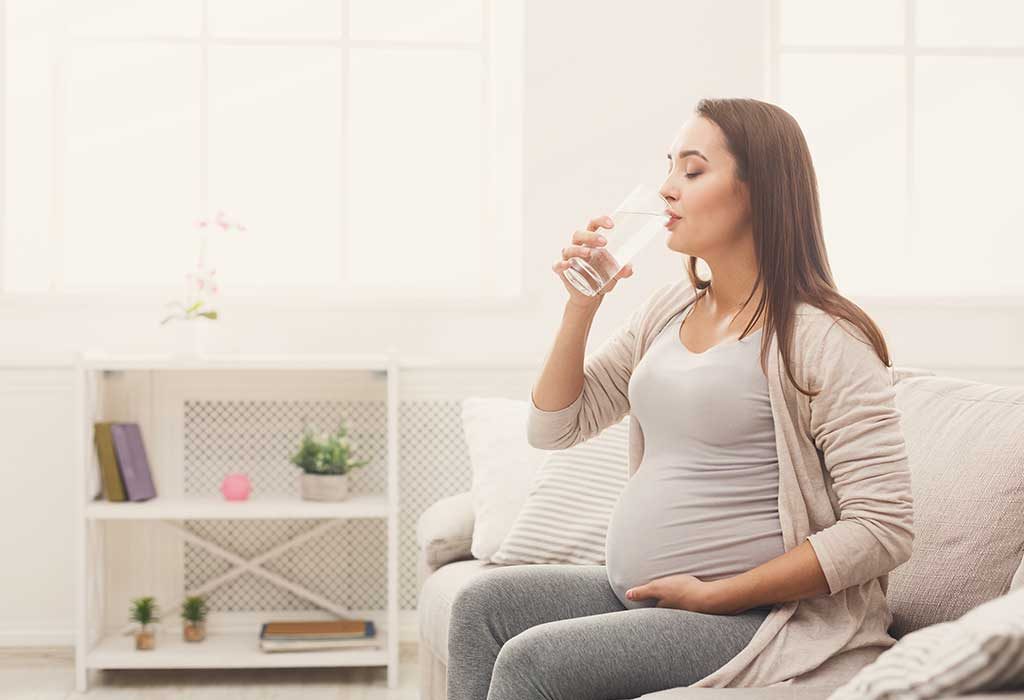 A pregnant woman drinking water