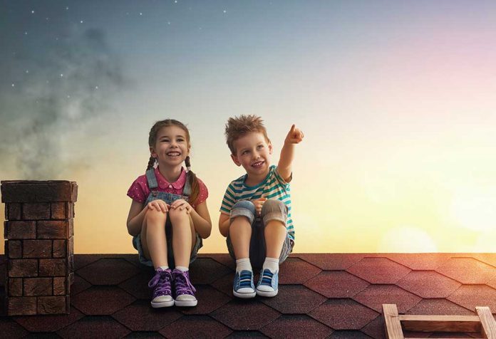 boy and girl watching the sky together on a roof