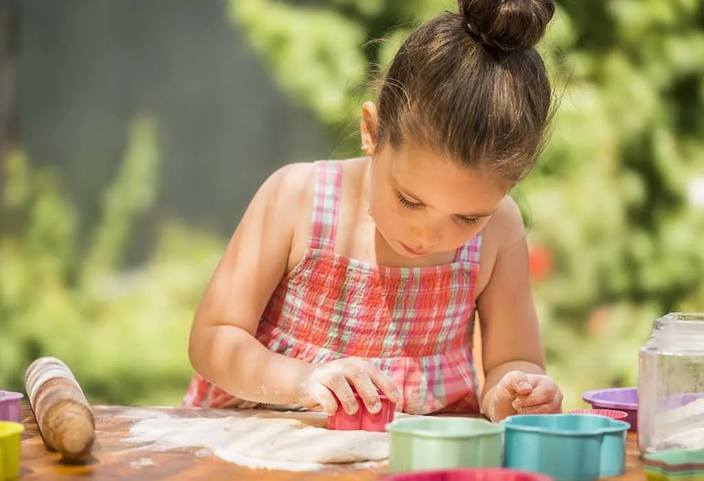 A girl baking cookies outdoors