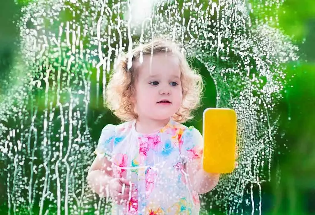 Toddler cleaning a glass window