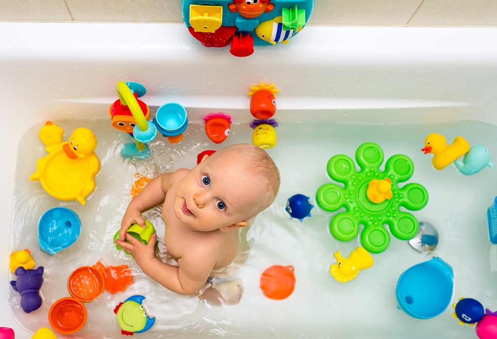 toddler in bathtub with colourful toys