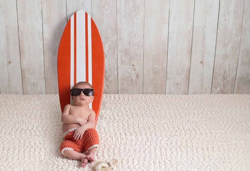 baby leaning on a surfboard