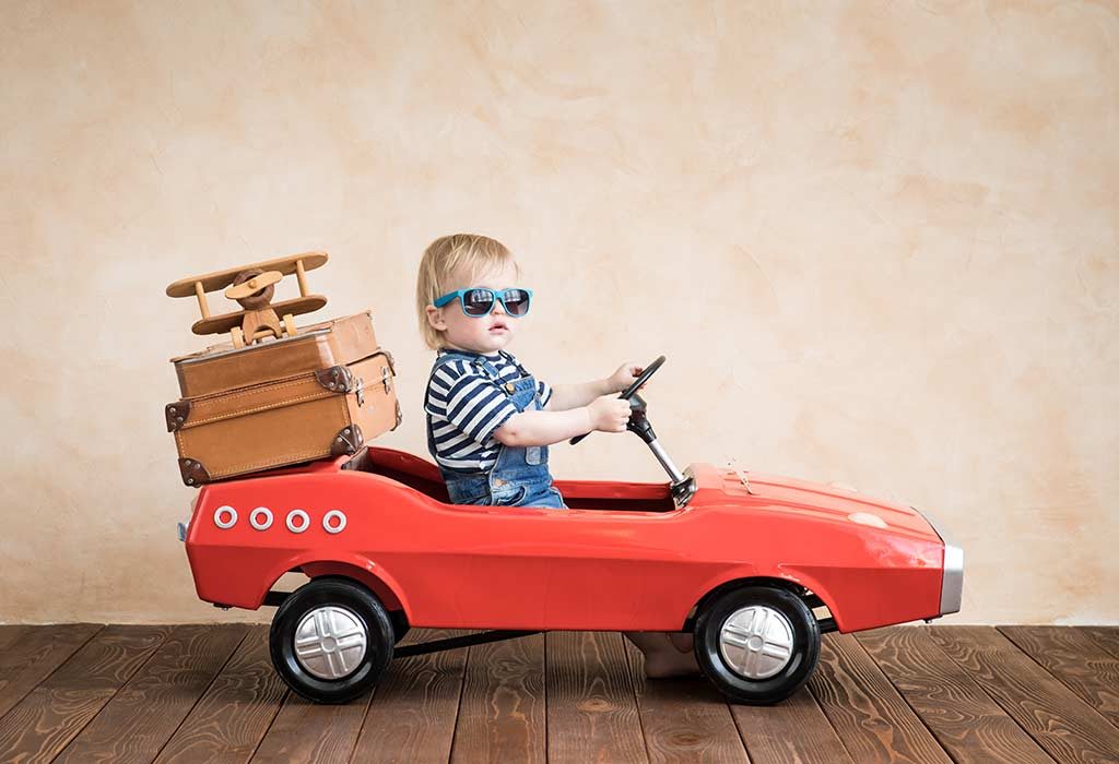 baby driving a toy car with luggage