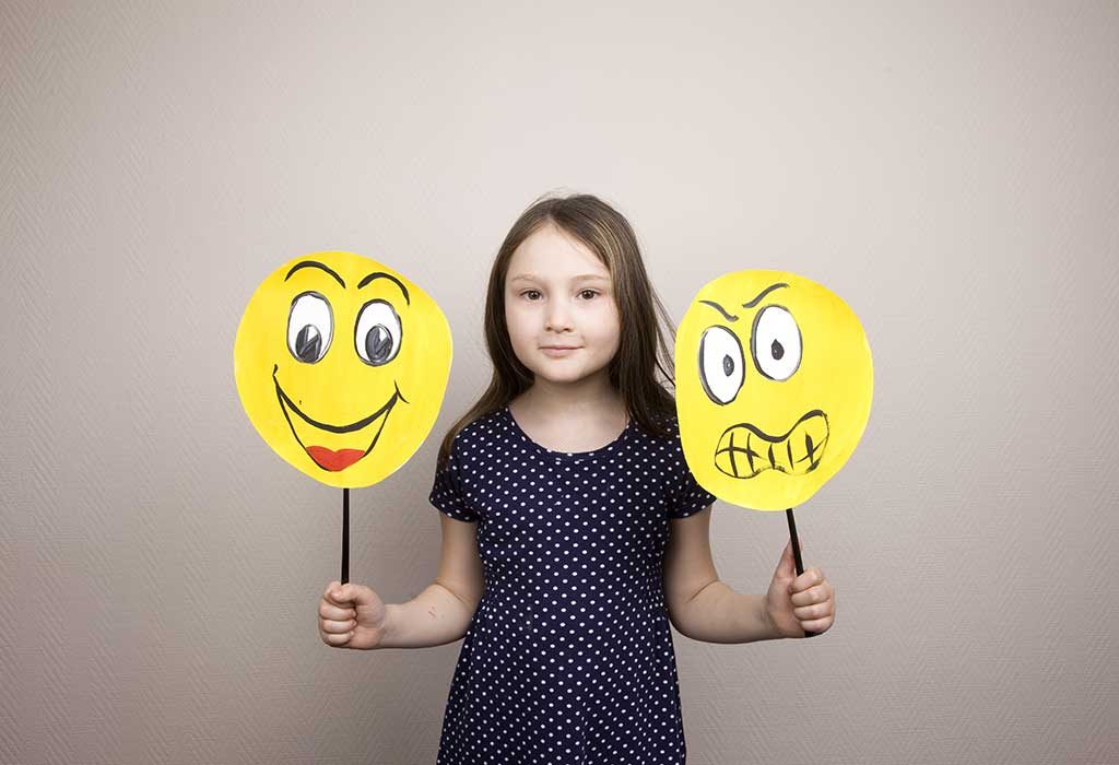 child holding emoticon signs