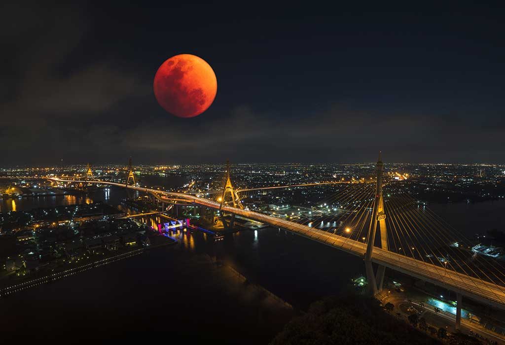 blood moon seen over a bustling city
