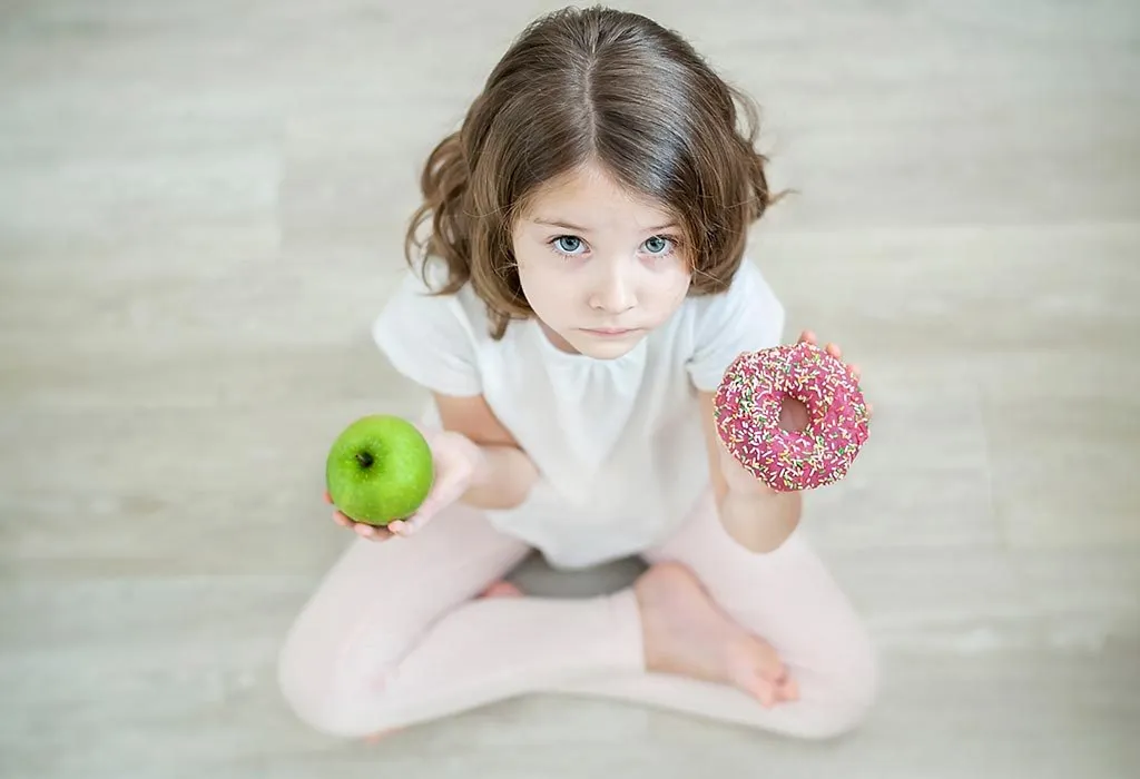 baby confused between a fruit and a doughnut