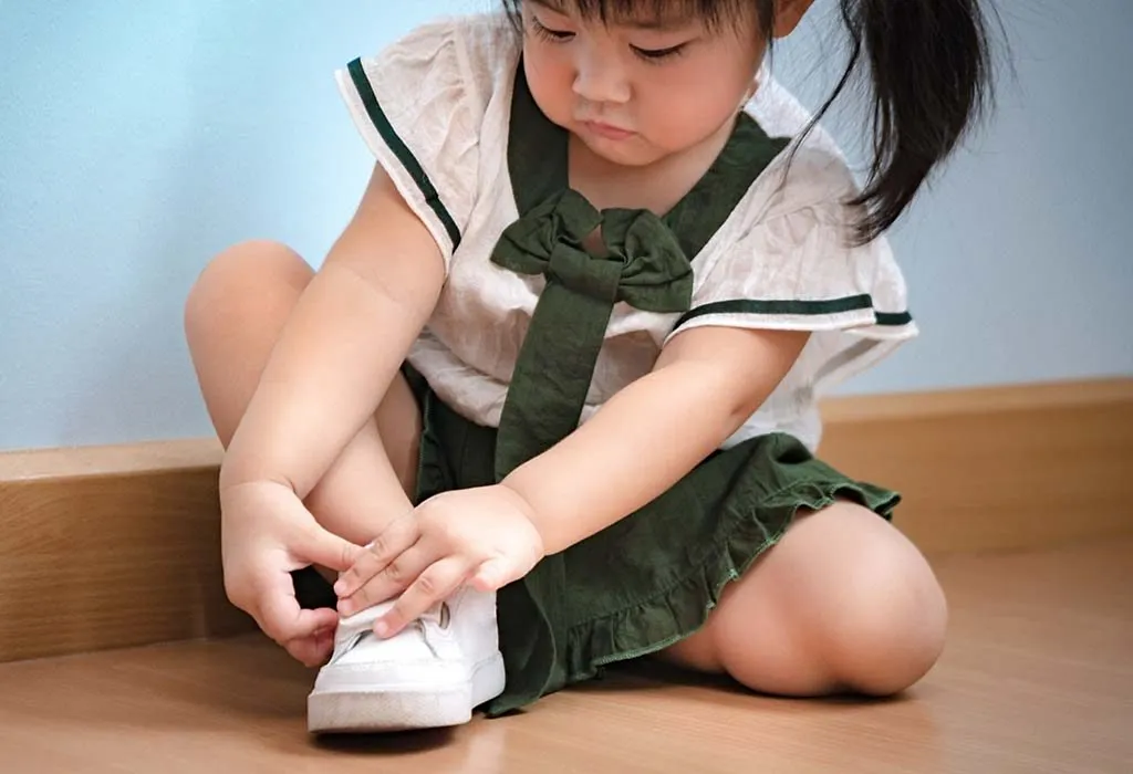 child putting on her shoes