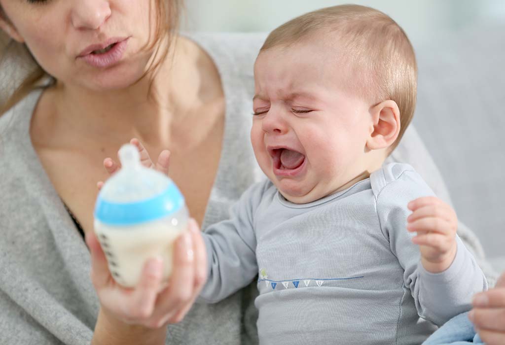 Un bambino che spinge via il biberon