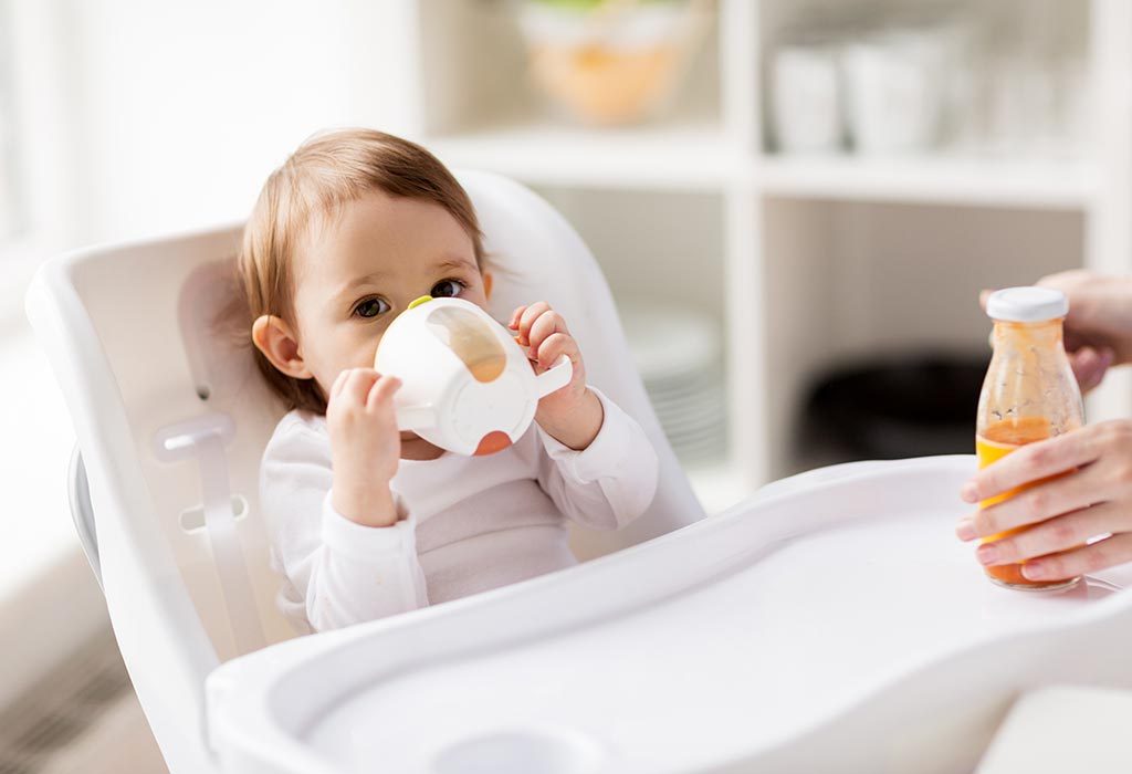 A baby sipping through sippy cup