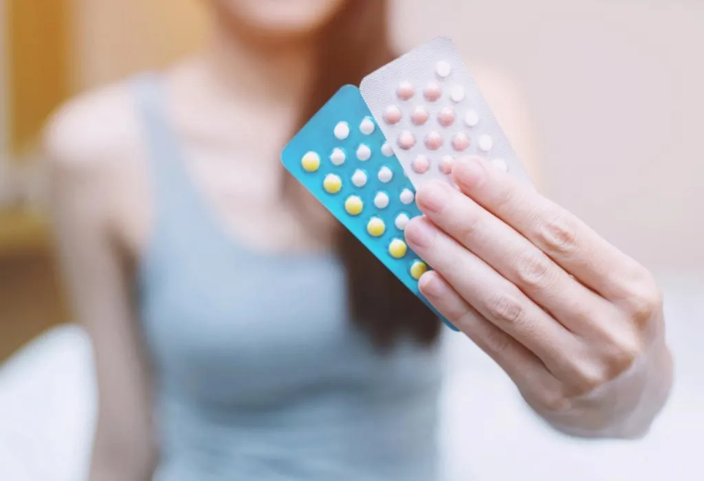 woman holding low dose birth control pills