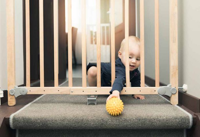 baby picking her ball through a baby safety gate