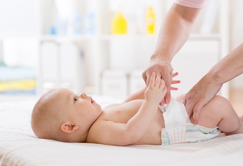 mom putting a diaper on her baby