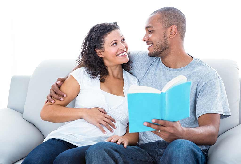 couple reading a baby name book