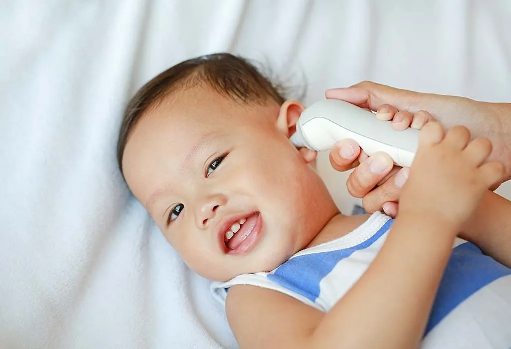 parent measuring baby's fever using an ear thermometer