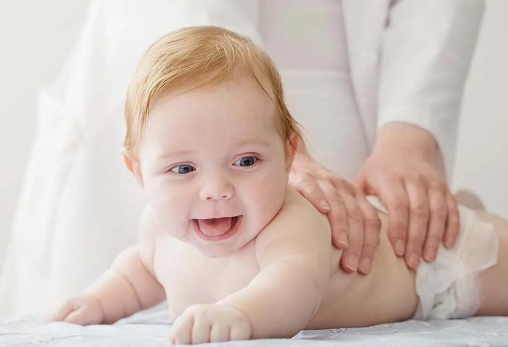 Baby massage - a mother massaging her newborn baby
