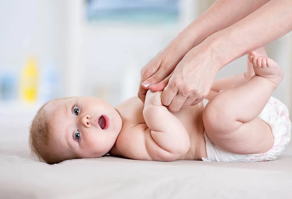 A mother massaging her baby
