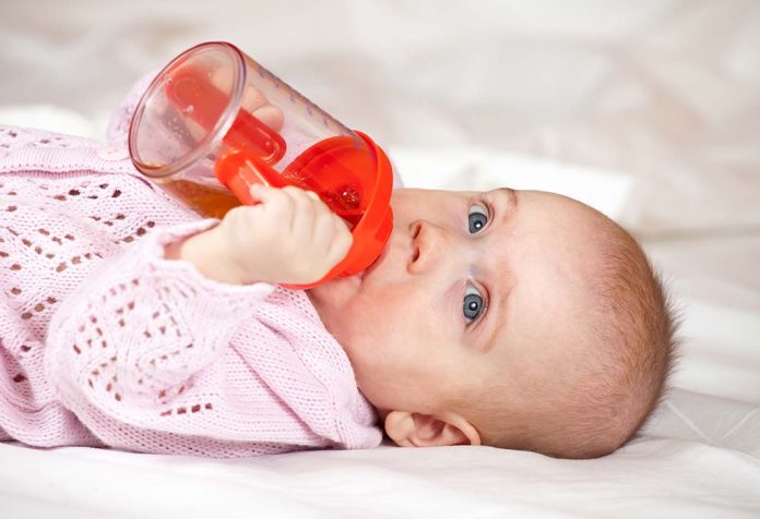baby drinking from a hard spout sipper cup