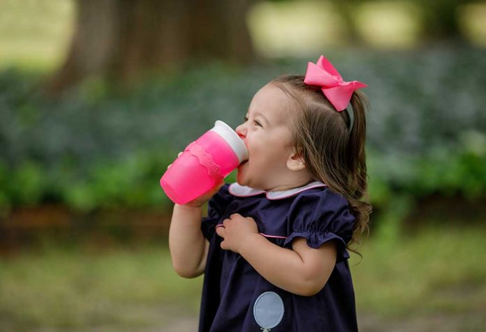 toddler drinking water from a sippy cup