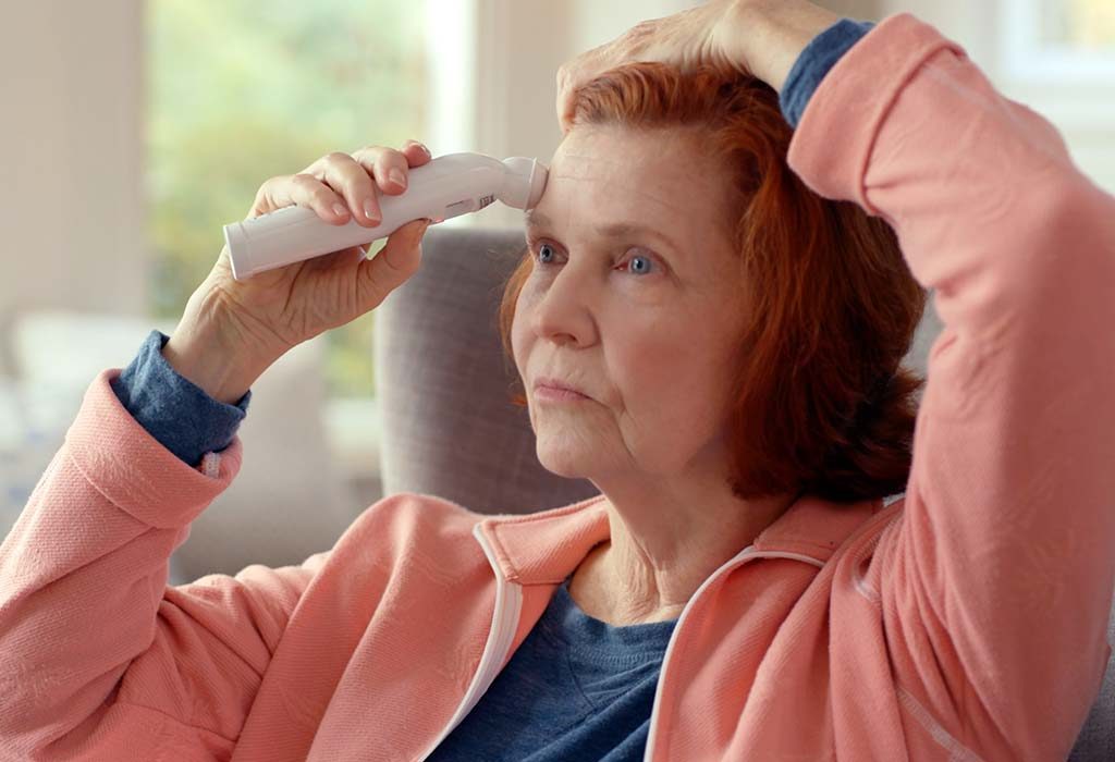 A woman checking her temperature with the Temporal Artery thermometer