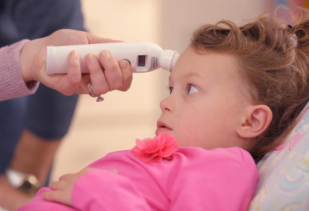 A woman using temporal artery thermometer to check her child's temperature