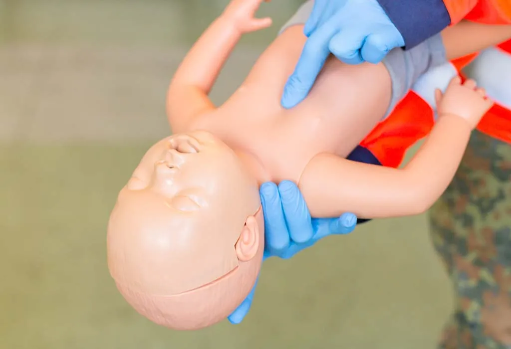 volunteer demonstrating the chest thrust technique for choking in babies