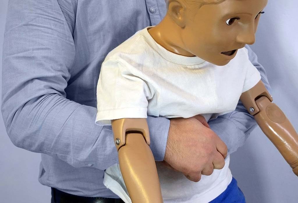 volunteer demonstrating abdominal thrust technique for choking in kids