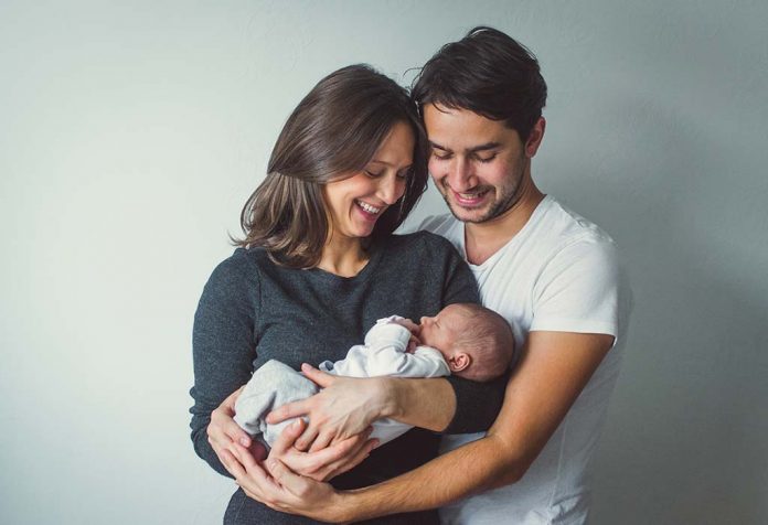 happy couple holding their newborn