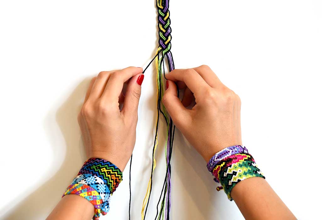 Woven DIY friendship bracelets handmade of embroidery bright thread with  knots on white background Stock Photo - Alamy