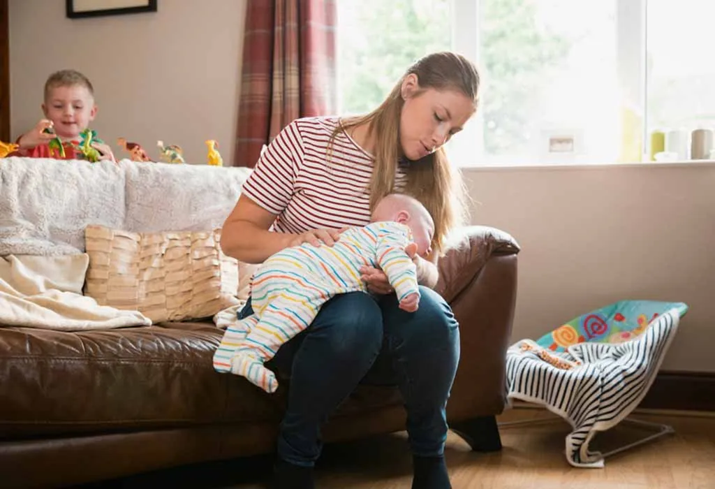 Mother burping baby on lap
